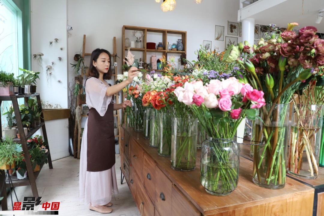 王黎媛是一名河南姑娘，在昆明念完大學(xué)后，就再也舍不下春城的藍(lán)天陽(yáng)光、青山碧水，更舍不下這里的四時(shí)繁花，于是就干脆留了下來(lái)，成了一名媒體人。2017年的時(shí)候又毅然辭去工作，創(chuàng)業(yè)開(kāi)起了花店，成了都市里的一名“花房姑娘”。圖為王黎媛在自己的花店中整理鮮花。新華網(wǎng) 周亞平/攝 念新洪/文